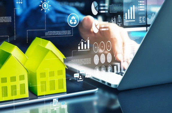 Grüne Häuser symbolisieren Ökostrom und digitale Lösungen für die Immobilienwirtschaft.